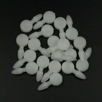 Texsolv Pfeilstecker in Weiß – runde Kunststoffstecker zur Fixierung von Texsolv Ösenschnur am Webstuhl, lose auf schwarzer Fläche verteilt